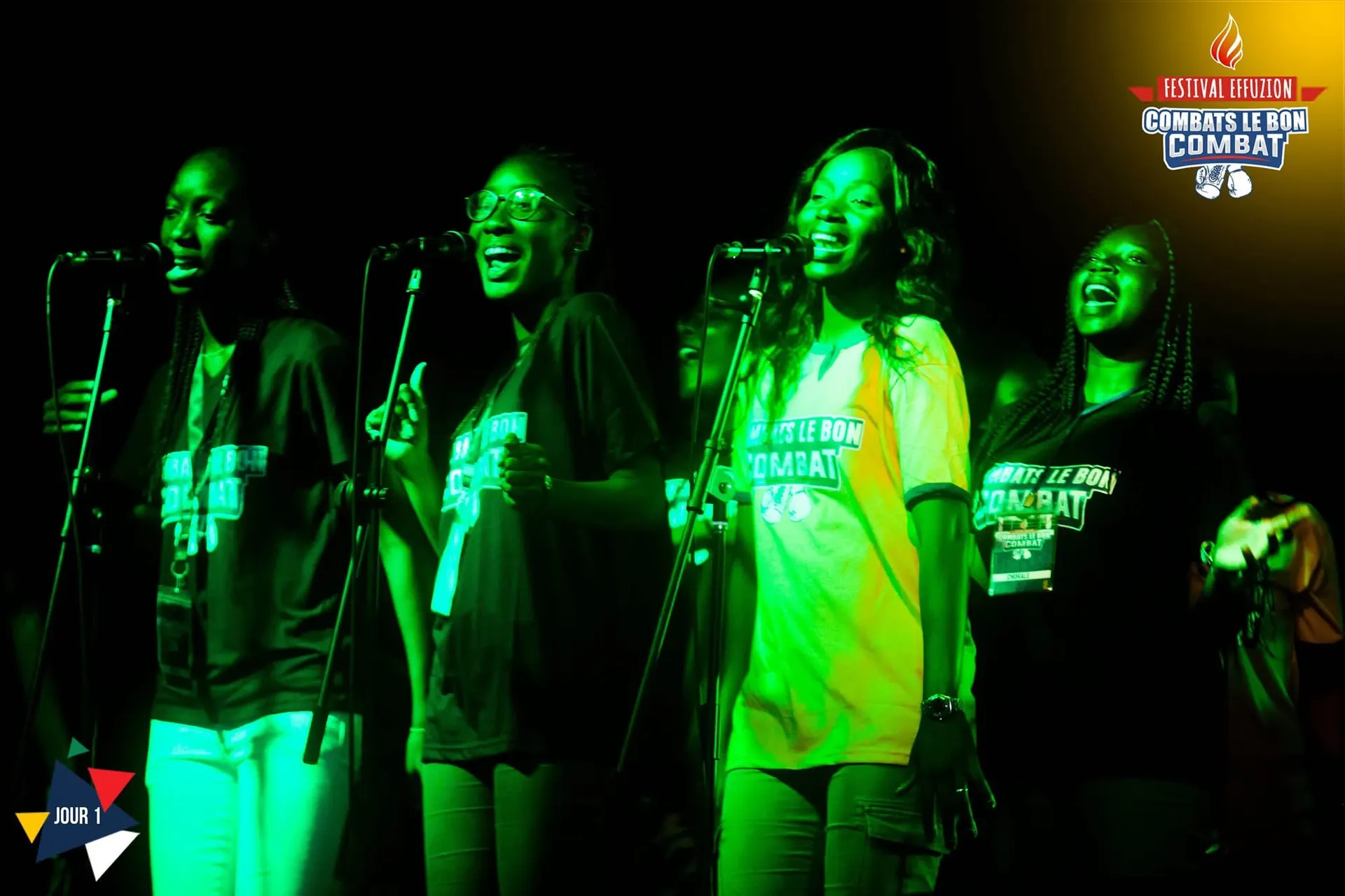 Quatre chanteuses en t-shirts du festival, sous une lumière verte. Photo de l’événement Effuzion.