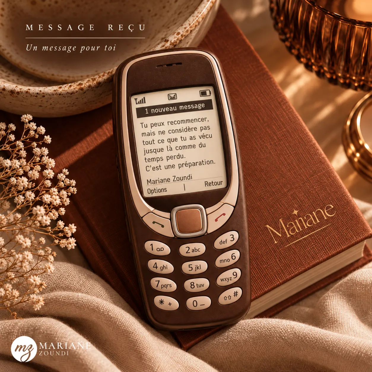 Visuel « Message reçu » : un ancien téléphone Nokia posé sur un livre affiche un message signé Mariane Zoundi.